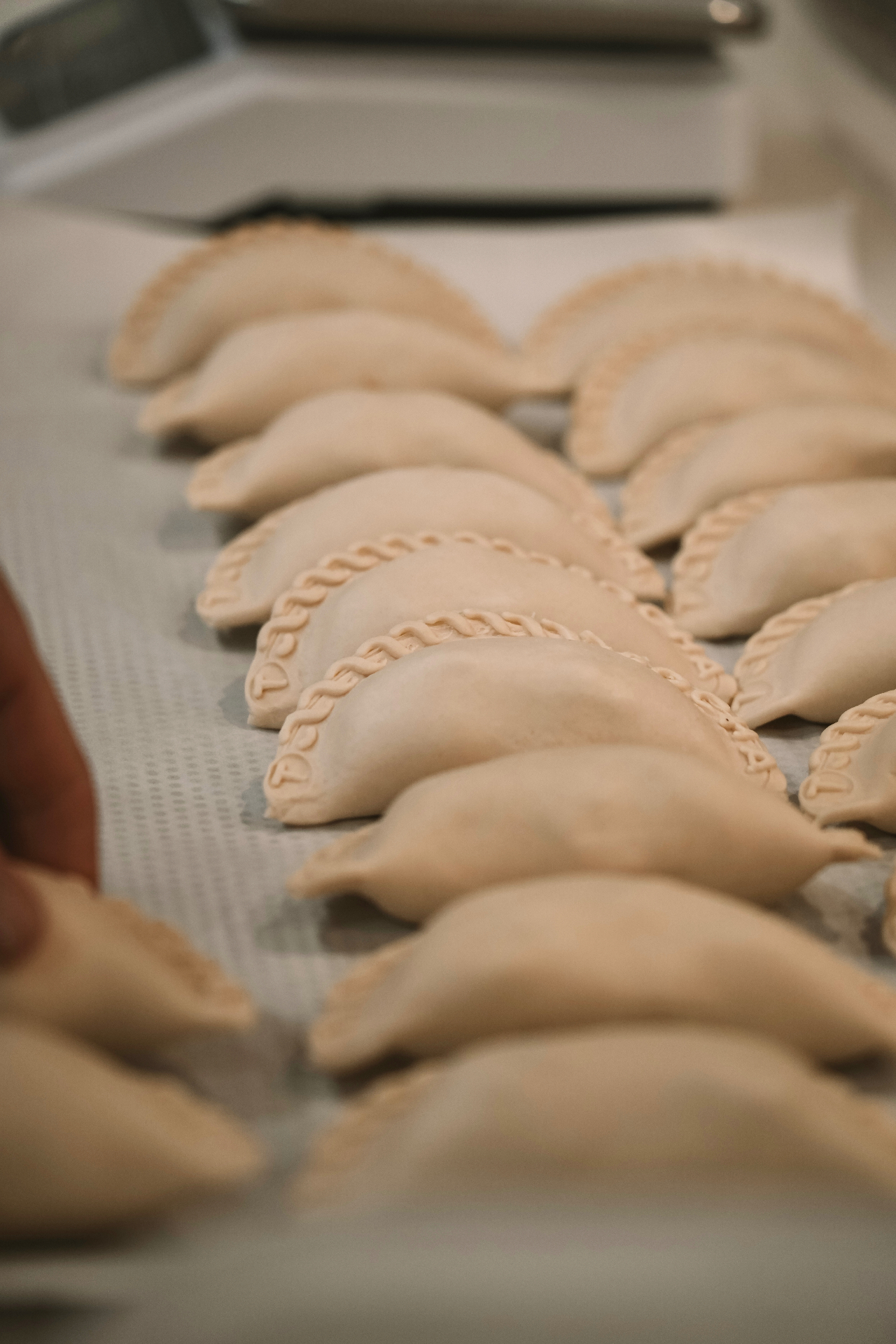 Trays of freshly shaped empanadas ready for baking in the Pocha kitchen