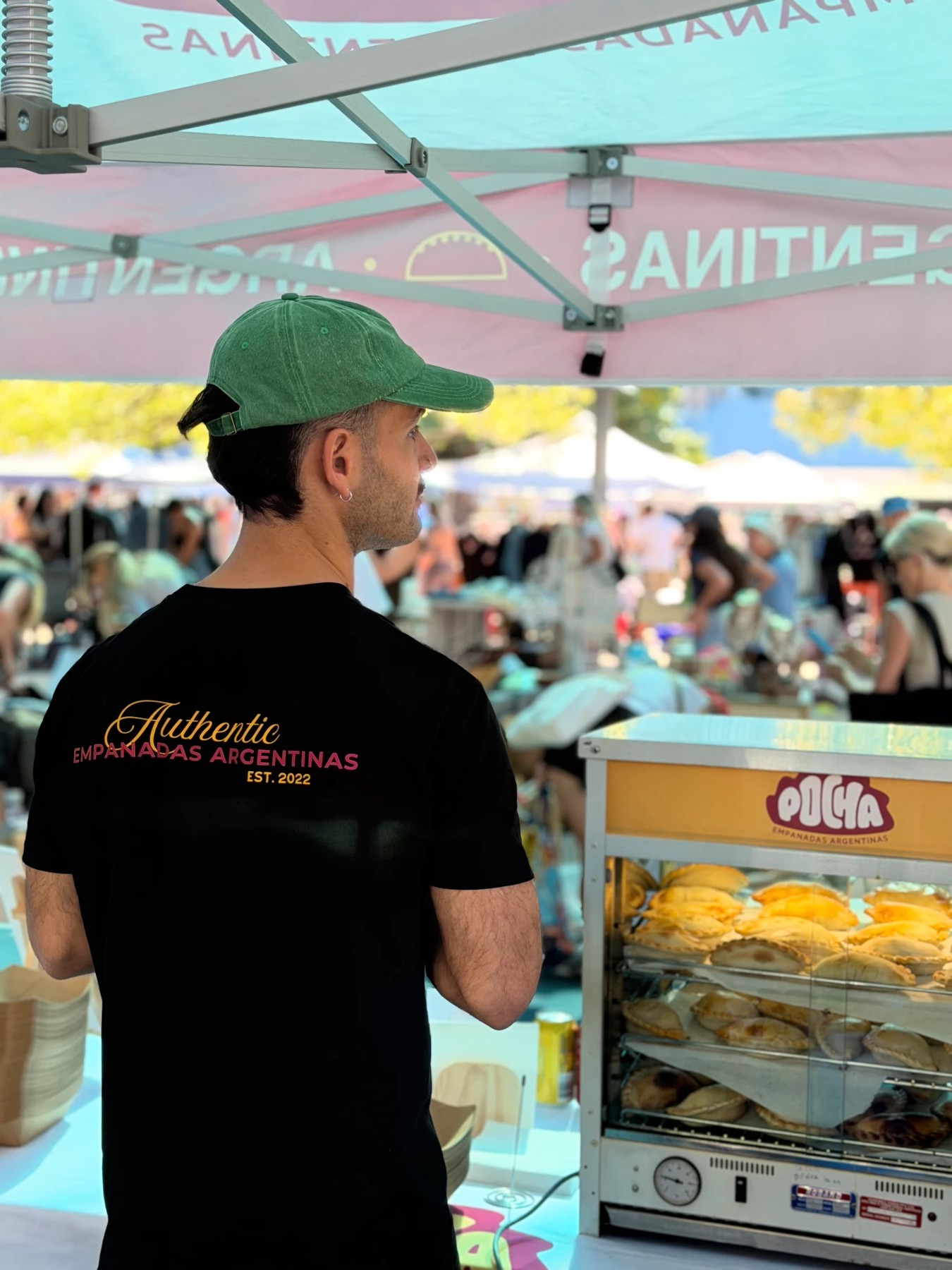The Pocha team serving golden empanadas from the market stall